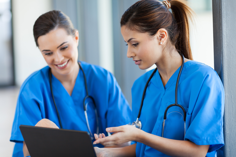 Two nurses looking up nclex requirements for their state